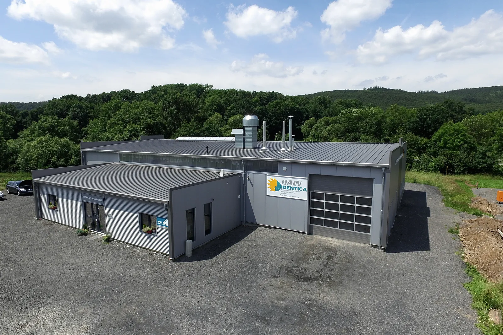 Halle am Ortsrand mit Wald dahinter