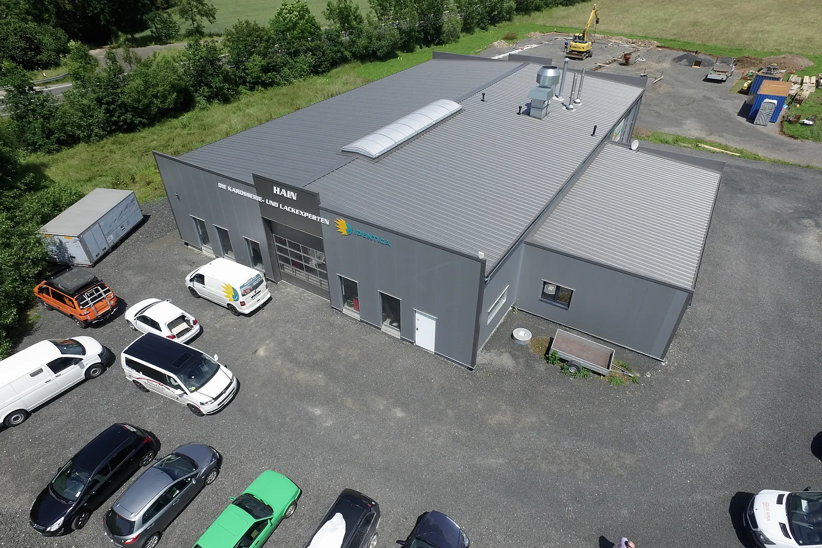 Luftbild mit Parkplatz und Kundenfahrzeugen