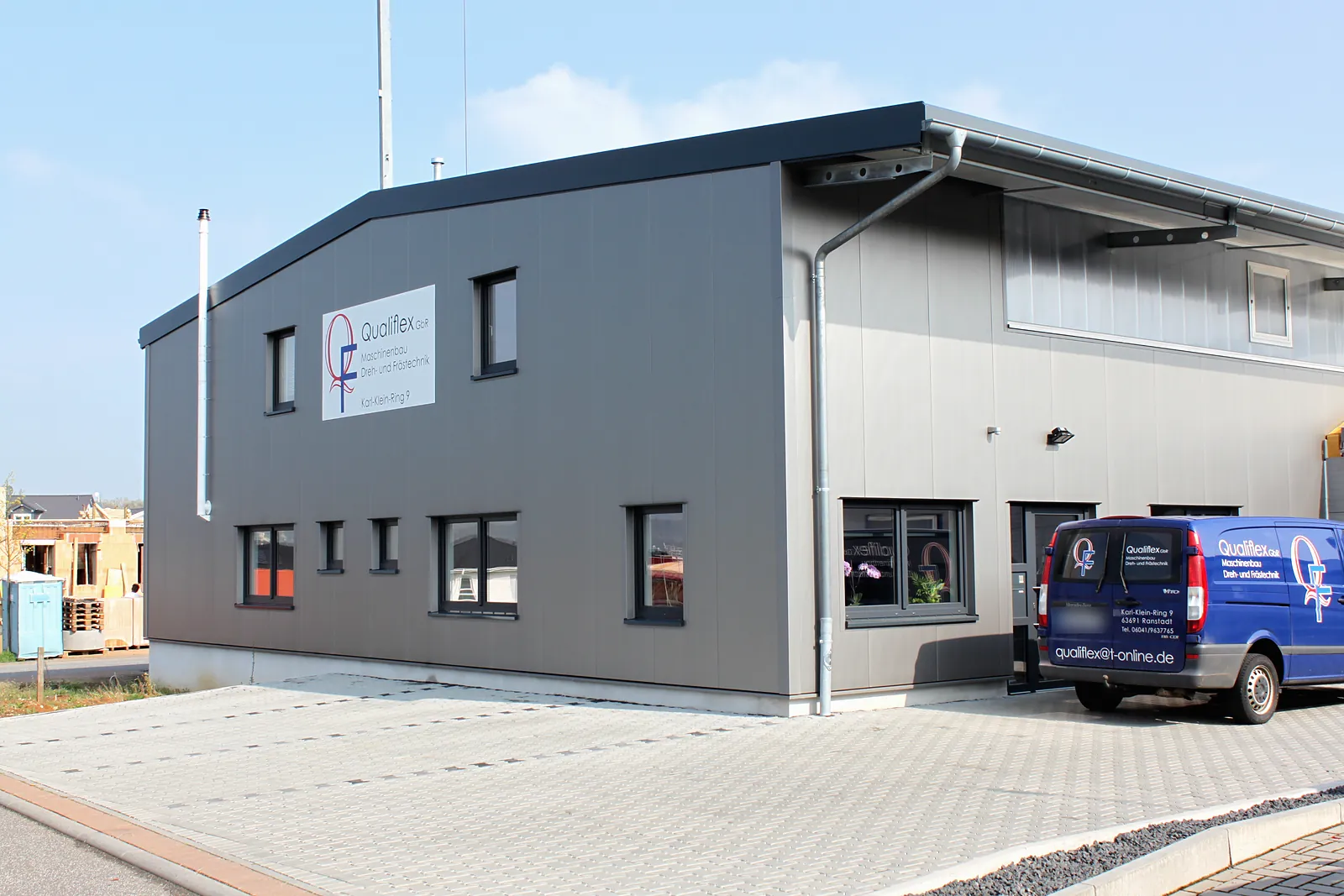 Halle mit zweigeschossigem Büroteil und dunkler Fassade