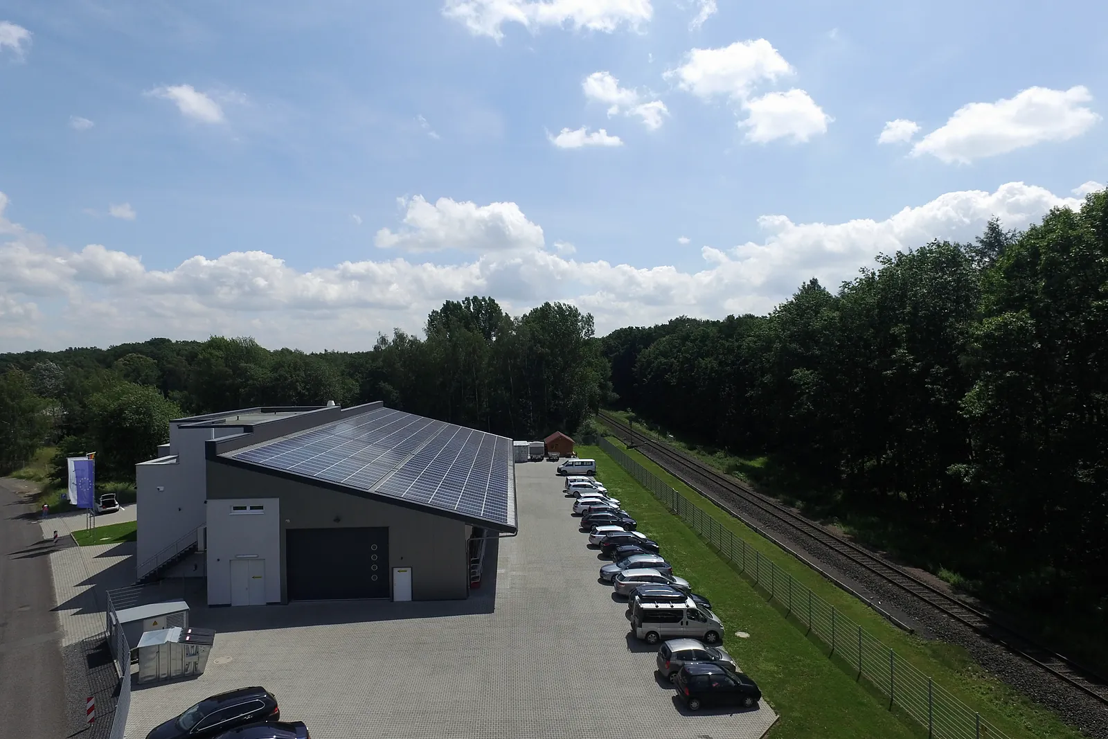 Halle mit Parkplatz und Wald