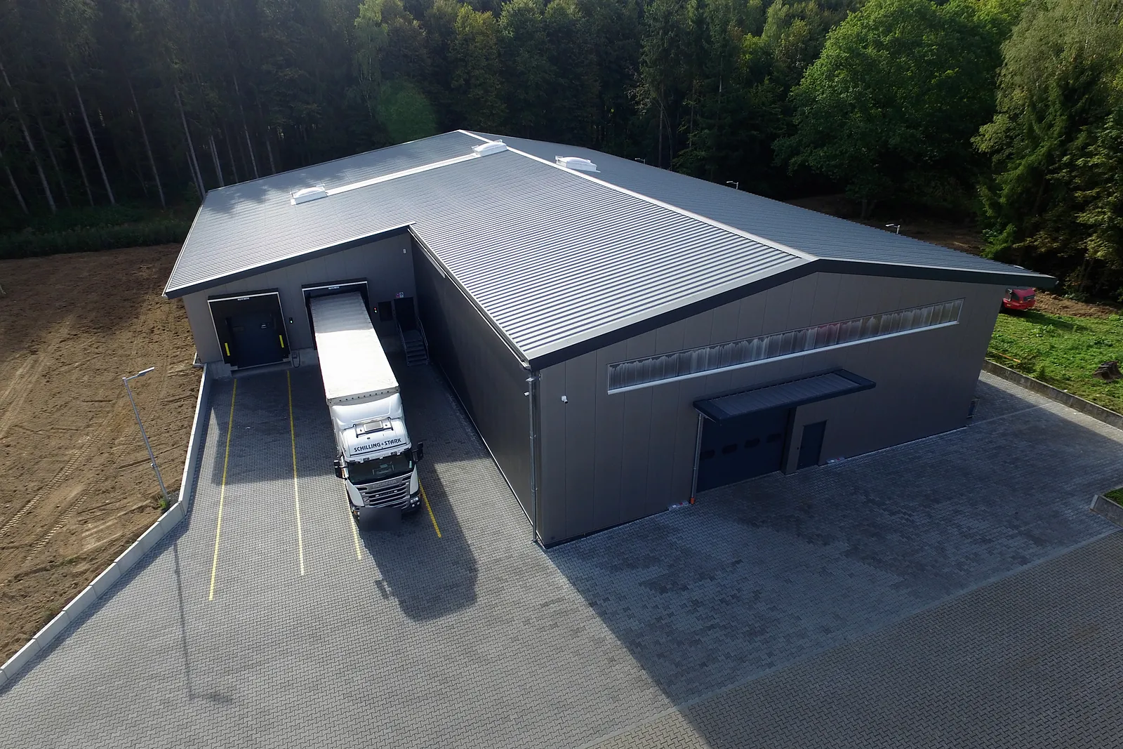 Luftbild der Lagerhalle mit Lkw an der Rampe