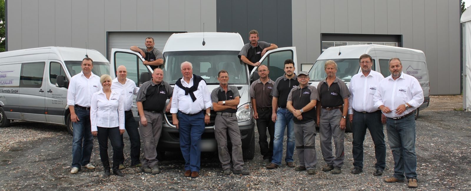 Das Team von Bergheimer Stahlhallen vor Firmenfahrzeugen und Hallen